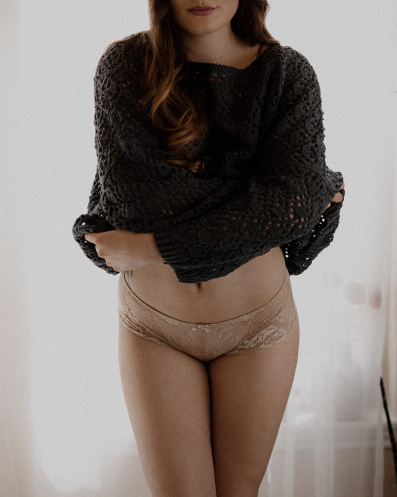 A woman in a navy sweater for boudoir style portraiture